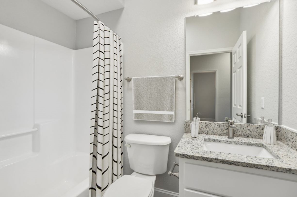 A bathroom with a toilet, sink, and shower.